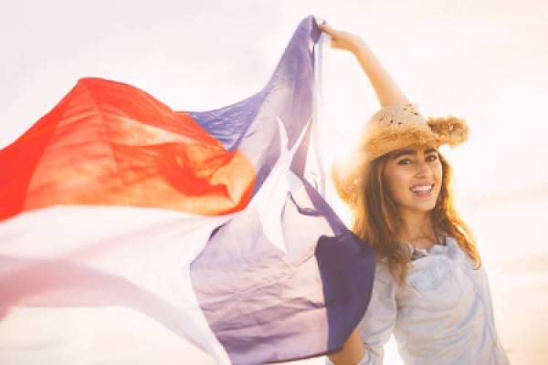 A woman holds up scarves in a breeze