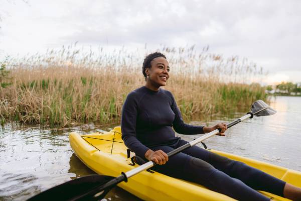 A woman kayaking near wetlands