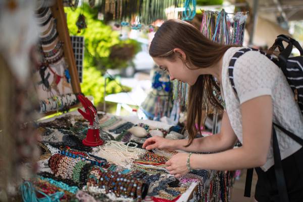 A woman browsing jewelry at a farmers market 
