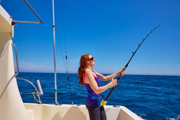 A woman fishes on a charter boat