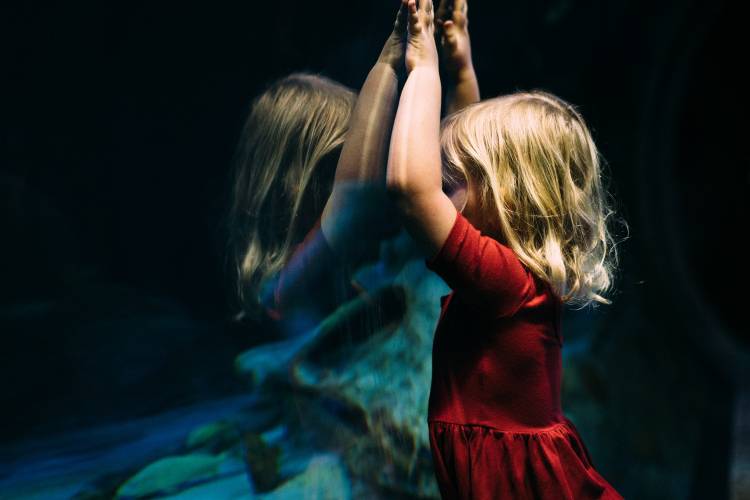 A girl observes a tank at an aquarium